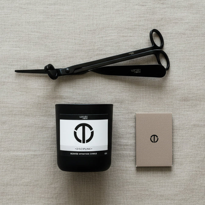 Matte black wick trimmer and wick dipper placed beside a candle  and a box of matches showing tools for safe candle care and clean burn performance.